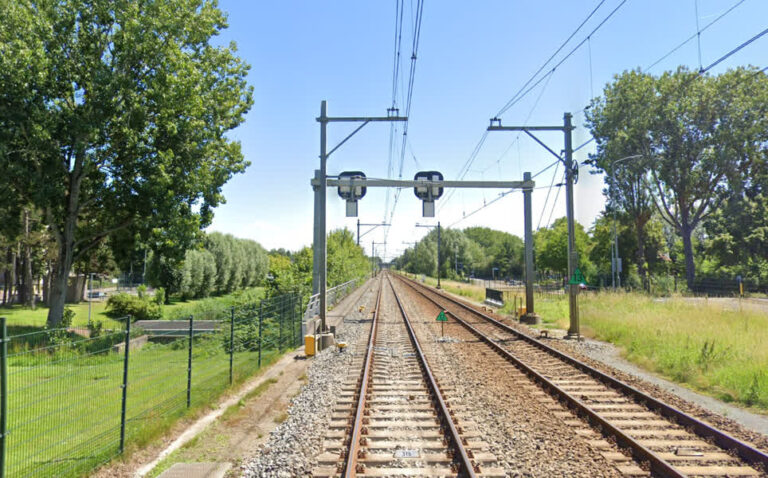 Man wandelt over het spoor naar het station