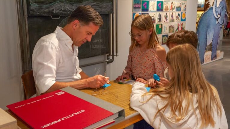 Mark Rutte deelt handtekeningen uit in Onderwijsmuseum:  voor ieder kindje van de bso één