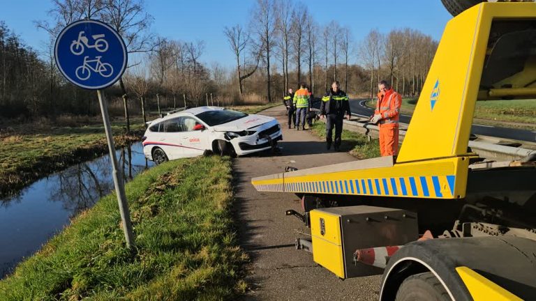 Auto schuift tientallen meters over vangrail en belandt in sloot
