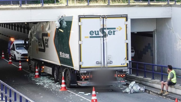 Te hoge vrachtwagen met tompoucen rijdt zich vast in tunnel en heeft nu open dak